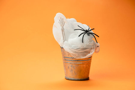 bucket with gauze web and black spider on orange background , Halloween conceptの写真素材