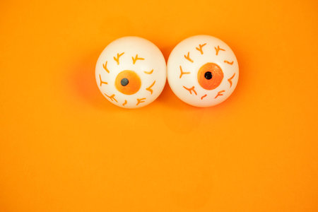 toy eyes on an orange background with a place for text, halloween conceptの写真素材