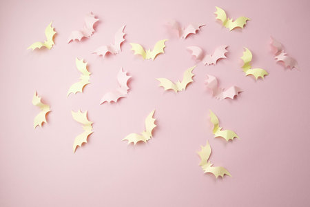 small light pink bats on a pink background with a place for text, the concept of a creative happy Halloweenの写真素材