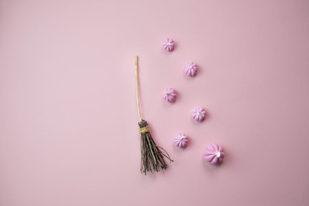 witchs broom on a light pink background with a place for text, the concept of a creative happy Halloweenの写真素材