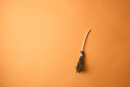 witchs broom on an orange background with a place for text, happy Halloween conceptの写真素材