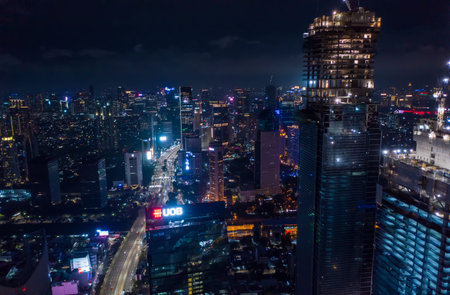 Close up aerial view of high rise skyscraper under construction in modern city center at night Tall...