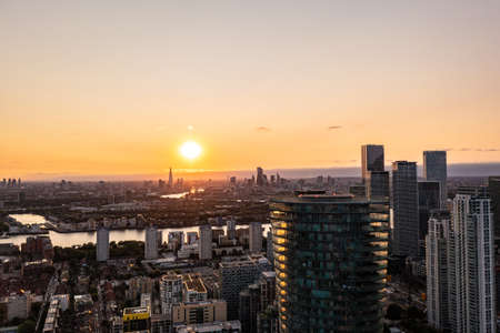 Panoramic aerial skyline view of east London at sunrise with skyscrapers of Canary Wharf and beautiful colorful sky at backgroundの写真素材