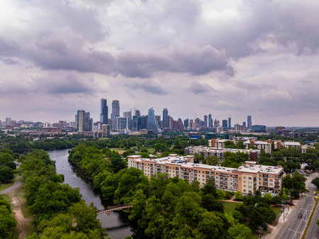 Austin, Texas skyline peeking through lush greenery and river, capturing the citys harmonious blend of urban and natural elements from aboveの写真素材