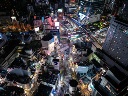 Aerial view of Shibuya crossing at night, Tokyo, Japan, illuminated by neon lights and vibrant...