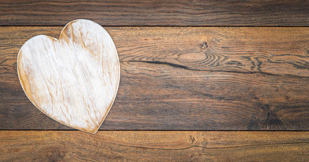 Retro classic Valentineâs Day cad, large white painted wooden hart isolated and on left side with large copy space on vintage oak panels â top viewの写真素材