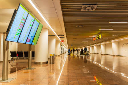 Brussels, Belgium, March 2019 Brussels airport, people are going for customs checks in long corridor with moving walkway and information board, arrival areaのeditorial素材