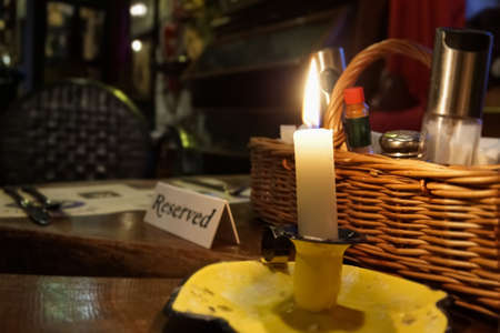 Restaurant reserved table sign with lit candleの写真素材