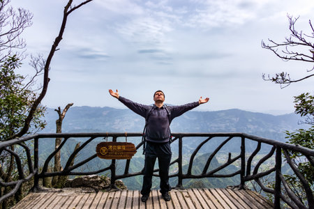 Caucasian male man standing on top of Tianman Mountain with pure satisfaction. Zhangjiajie, Hunan,...