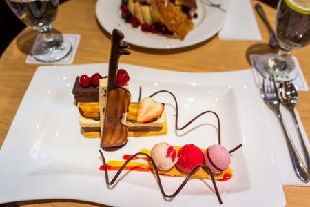 Delicious colourful layers of ice creams with fresh strawberry and cherries, chocolate violin and...