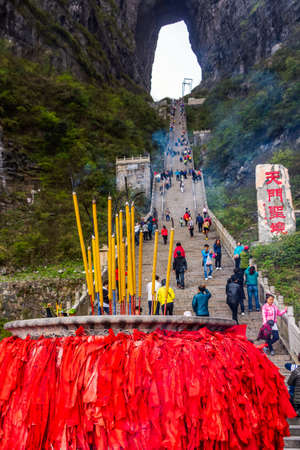 Zhangjiajie, Hunan, China Apr 2013 Incense pot on the bottom platform and tourists climbing 999 stairs to Haven Gate in Tianman Mountainsのeditorial素材