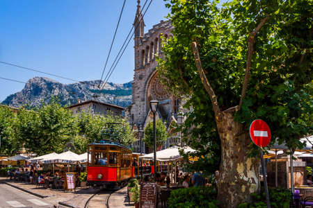 Soller, Mallorca, Spain, July 2015 Classic, heritage wood tram serving town of Soller and village Port de Soller, St Bartholomew church in backgroundのeditorial素材