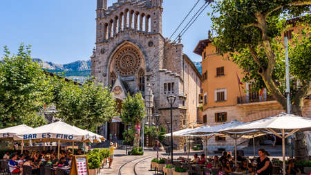 Soller, Mallorca, Spain, July 2015 St Bartholomew church and city square with vintage tramline and restaurants in Solerのeditorial素材