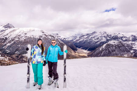 Two adults, happy and smiling woman on winter holidays in snowy mountains, skiers with ski equipment, Livigno, Italy, Alpsの写真素材
