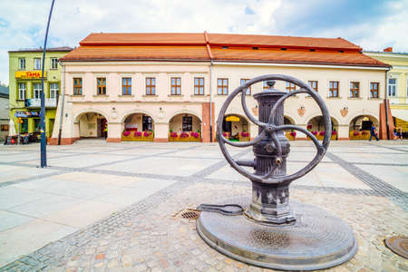 Kielce, Swietokrzyskie, Poland, June 2016 Vintage water pump with wheel on marketplace. Museum of Dialogue of Cultures in the backgroundのeditorial素材