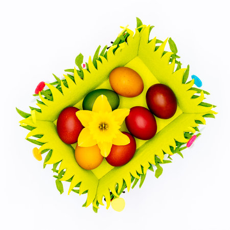 Stash of colourful Easter eggs, wax hand painted and decorated with daffodil in a felt Easter basket...