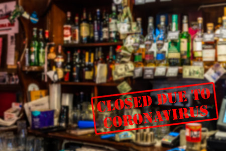 Defocused, blurred view of interior of traditional bar or pub, empty and closed due to coronavirus...