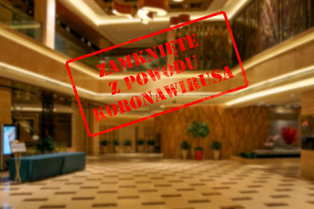 Defocused view of interior of upmarket hotel reception or hall, empty and closed due to covid 19 pandemic with Polish notice Closed due to Coronavirusの写真素材
