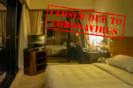 Defocused, blurred view of interior of an upmarket hotel or motel room, empty and closed due to...