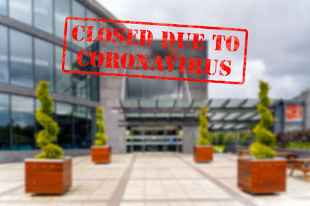 Defocused, blurred view of exterior of modern theatre or cinema, empty and closed due to coronavirus or covid 19 pandemicsの写真素材