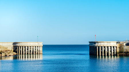 Symmetric breakwaters on entrance to Greystones marina in County Wicklow with view on calm Irish...