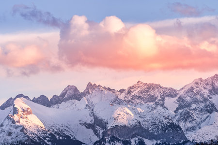 Sunset with dramatic sky and snowy mountain peaks illuminated by sunlight, Tatra Mountains in winter time. Mountain range in Bialka Tatrzanska, Polandの写真素材