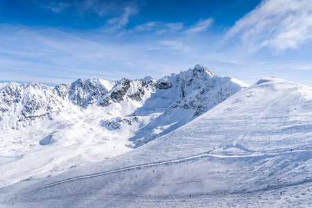 People skiing and snowboarding from Kasprowy Wierch, winter holidays. Amazing mountain range with...