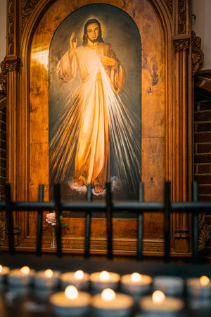 Szczecin, Poland, June 2019 Painting of Jesus Christ with lit candles in The Cathedral Basilica of...