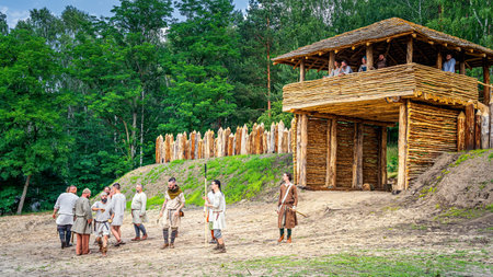 Cedynia Poland June 2019 Historical reenactment of Slavic or Vikings warriors in front of wooden fort with palisade and tower from 11th centuryのeditorial素材
