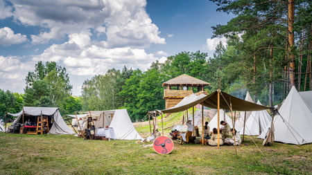 Cedynia Poland June 2019 Historical reenactment of Slavic or Vikings tribe encampment with wooden palisade, fort tower and tent camp from 11th centuryのeditorial素材