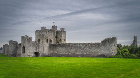 Panoramic view on old and ruined Trim Castle from 12th century, fortification walls with dark moody sky in Trim village, County Meath, Irelandの写真素材