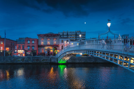 Dublin, Ireland, August 2019 Beautiful Ha Penny metal pedestrian bridge over Liffey River on Tempel...
