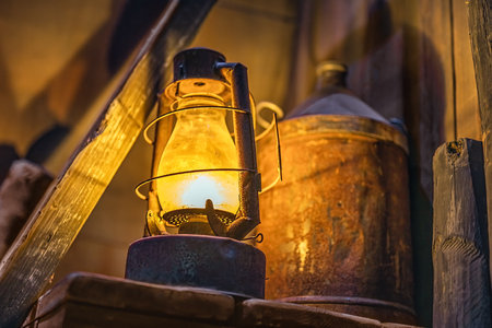 Selective focus on lit rusty storm lamp and vintage equipment in abandoned factory, workshop or shipyard in Belfast, Northern Irelandの写真素材