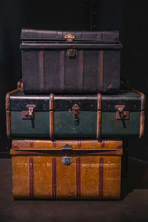 Selective focus on pile of three vintage, old and warn travel suitcases or trunks on the floor. Retro style voyage.の写真素材
