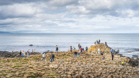 Bushmills, Northern Ireland, Aug 2019 Tourists sightseeing hexagonal rock formation in Giants Causeway, Wild Atlantic Way and UNESCO world heritageのeditorial素材