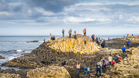 Bushmills, Northern Ireland, Aug 2019 Tourists sightseeing hexagonal rock formation in Giants Causeway, Wild Atlantic Way and UNESCO world heritageのeditorial素材