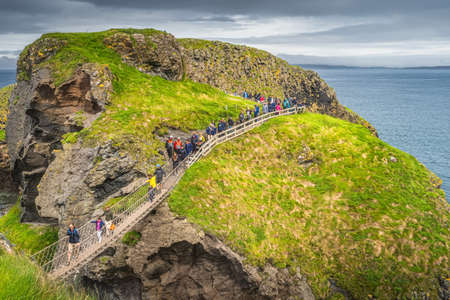 Ballycastle, August 2019 Group of people and families crossing Carrick a Rede rope bridge, Wild Atlantic Way, Northern Irelandのeditorial素材