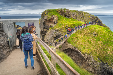 Ballycastle, August 2019 Group of people queueing to crossing Carrick a Rede rope bridge, Wild Atlantic Way, Northern Irelandのeditorial素材