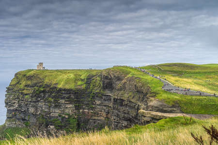 Crowds of tourists walking on stairs to OBriens Tower on iconic Cliffs of Moher, popular tourist attraction, , Wild Atlantic Way, Clare, Irelandの写真素材