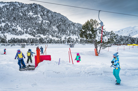 Ski trainers teaching group of young kids how to ski in ski school Mother watching her daughter on ski Winter holidays in Andorra Pyrenees Mountainsのeditorial素材