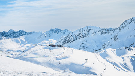 Ski lift cross centre on a snowy peak in beautiful winter scenery with mountain range in a background, Andorra, El Tarter, Pyrenees Mountainsの写真素材