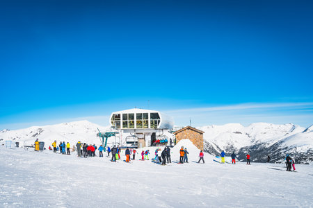 People, families, skiers and snowboarders taking off from ski lift and having fun in winter, El Tarter, Grandvalira, Andorra, Pyrenees Mountainsの写真素材