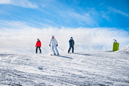 Man and woman skiing down the ski slope or piste in Pyrenees Mountains. Winter ski holidays in El Tarter, Grandvalira, Andorraの写真素材