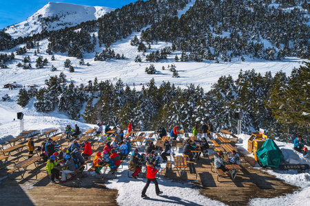 El Tarter, Andorra, Jan 2020 People sitting at the tables relaxing and eating with a beautiful view on snowy mountains and forest. Winter ski holidaysのeditorial素材