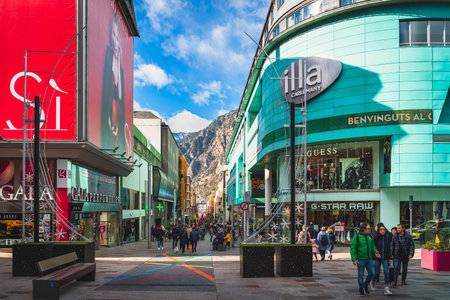 Andorra la Vella, Andorra, Jan 2020 Crowd of people walking and shopping on promenade with Pyrenees Mountains in background. Ski winter holidaysのeditorial素材