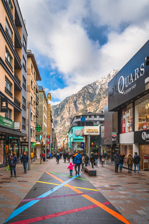 Andorra la Vella, Andorra, Jan 2020 People walking and shopping on promenade with shops and restaurants, Pyrenees Mountains in backgroundのeditorial素材