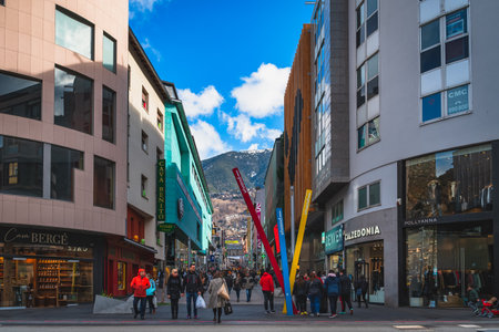 Andorra la Vella, Andorra, Jan 2020 People walking and shopping on promenade, street with shops and restaurants, Pyrenees Mountain range in backgroundのeditorial素材
