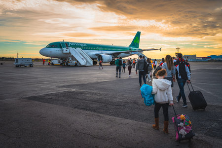 Perpignan, France, Jan People going to airplane parked on airport runway. Tourists boarding Aer...