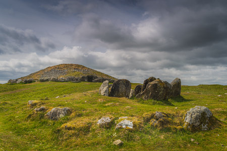 Ancient, dating back to 3000 BCE, neolithic burial chambers and stone circles of Loughcrew Cairns with dramatic, dark sky in County Meath, Irelandの写真素材