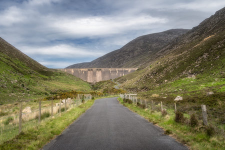 A charming pathway gently winds through an inviting, vibrant Silent Valley Reservoir, showcasing a...